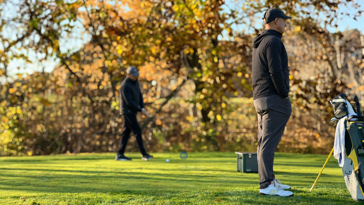 Golfers playing an autumn round among fall foliage