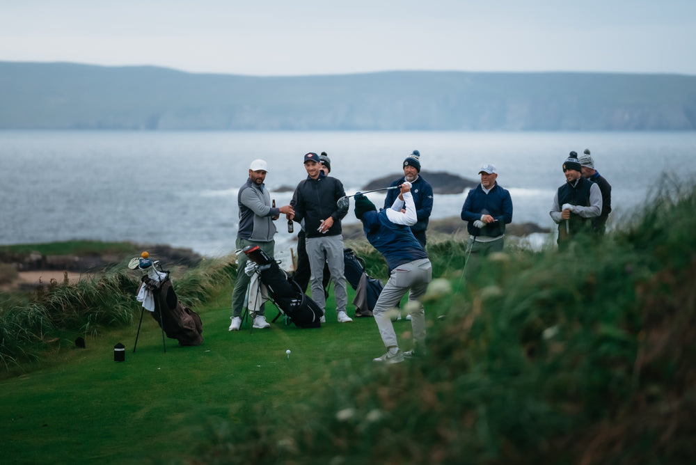 Group of golfers playing on a seaside links course with coastal ocean backdrop